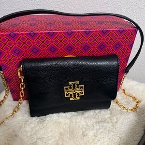 Small purse with gold chain strap .
